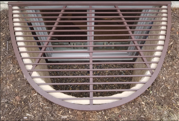 Heavy-duty bar window well grate installed on a window well